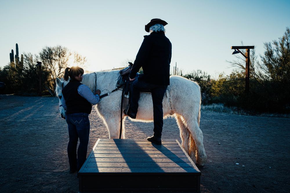 Mounting a horse at dusk